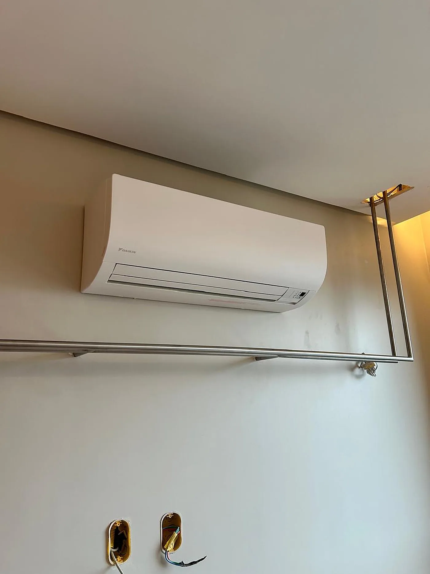 Split Hi-Wall Daikin instalado em parede, com caixas elétricas ainda abertas